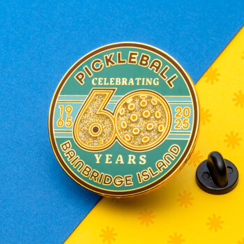 Circular lapel pin celebrating 60 years of pickleball on Bainbridge Island with gold glitter numbers and a pickleball design on a teal and green background.