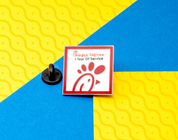 Chick-fil-A Saginaw 1 Year of Service square lapel pin with red logo on a white background and red border.