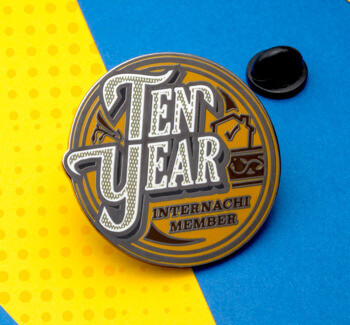 Circular InterNACHI Ten Year Member lapel pin with black and gold enamel on a blue and yellow background.