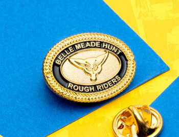 Gold oval lapel pin with black enamel border featuring Belle Meade Hunt Rough Riders text and a fox head emblem.