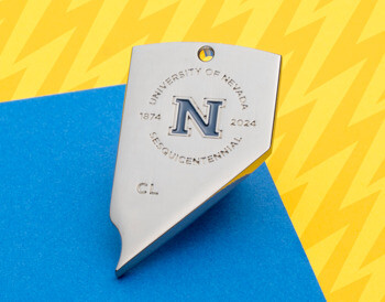 Silver Nevada state-shaped lapel pin featuring the University of Nevada Sesquicentennial logo and a blue block N.