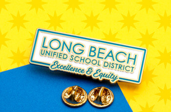 Rectangular enamel lapel pin for Long Beach Unified School District with white background and teal lettering.