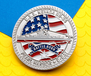 USS Nevada BB-36 challenge coin with a battleship design, American flag background, and Battle Born, Pearl Harbor & D-Day inscriptions on a blue and yellow back